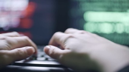 Wall Mural - tracking shot of hands of female hacker pressing buttons on black computer keyboard; defocused scree