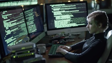 Wall Mural - tracking of young woman with short haircut typing program code on keyboard while working on computer