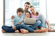 © pikselstock - Happy family using laptop together
