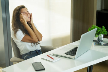 Woman with headache in office