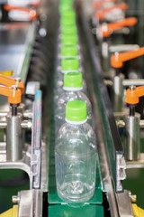 Wall Mural - plastic bottle on factory line machine in the factory, selective focus.