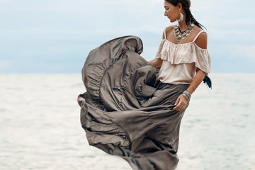 Wall Mural - beautiful young woman in elegant dress on the beach