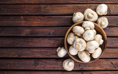 Wall Mural - Top view of mushrooms champignon on wooden table. Copy space.