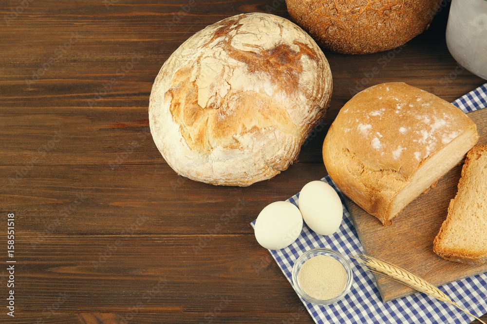 Bread and ingredients on wooden table