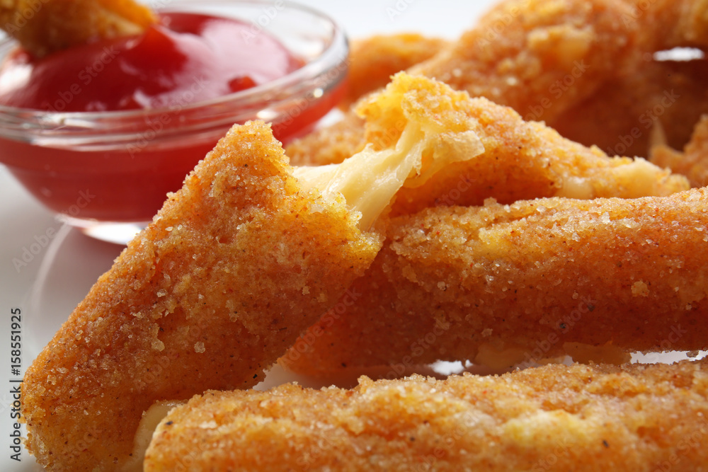 Delicious fried cheese sticks on white plate