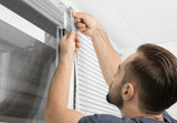 Fototapeta Na drzwi - Man installing window blinds at home, close up