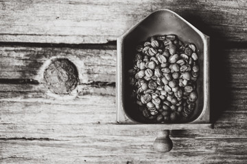 Top view of coffee beans on Coffee grinder tray, wood background, Colour B&W retro style