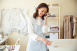 © Drobot Dean - Woman seamstress talking on phone and drinking coffee