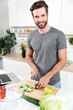 © Drobot Dean - Smiling man preparing vegetable salad in the modern guy