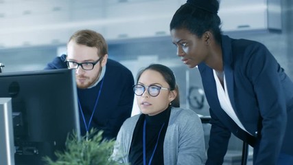Wall Mural - diverse team of scientific engineers doing research on a computer in a high tech laboratory on a hig