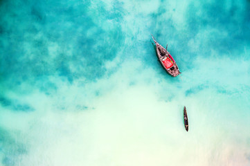 boat and ship in beautiful turquoise ocean near an island, top view, aerial photo