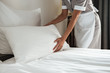 © Drobot Dean - Cropped image of a chambermaid making bed in hotel room