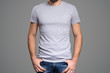 © yuriyzhuravov - Gray t-shirt on a young man template. Gray background.