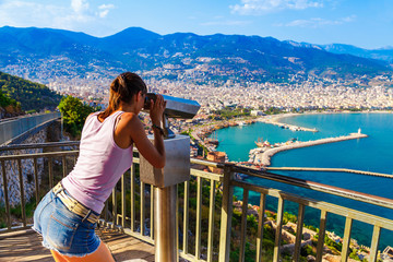 Wall Mural - Woman look on landscape of Alanya with marina and Kizil Kule red tower in Antalya district, Turkey, Asia. Famous tourist destination with high mountains. Summer bright day and sea shore