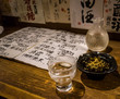 Traditional japanese sake and seaweed. Japanese menu and sake brands in the background.