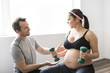© Louis-Paul Photo - Pregnant woman working out with dumbbells with personal trainer at the gym