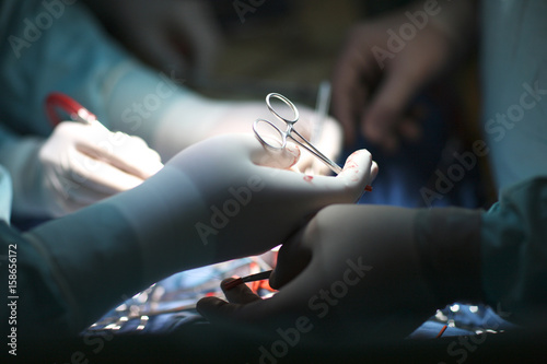 Plakat Dłonie chirurga i asystenta w czasie operacji
