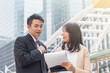 © lersan - The businessman and the businesswoman talking about business project in downtown with building background