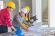 © lersan - Group of engineer checking the blueprint on the table and talking about construction project with commitment to success at construction site
