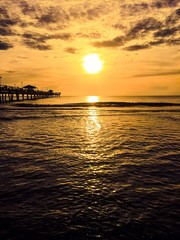 Wall Mural - Sun reflects on the sea and the pier in orange color shade style