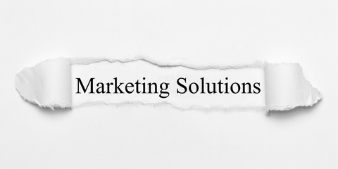 Marketing Solutions on white torn paper