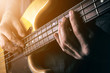 Live rock music background, electric bass guitar over bright blurred stage lights, close up