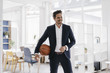 © Westend61 - Businessman holding basketball in office