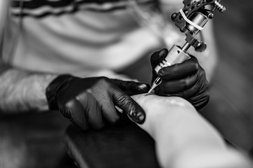 Tattoo artist tattooing young woman