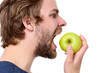 Man with beard and moustache going to bite green apple