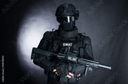 Plakat Członek oddziału SWAT z karabinem szturmowym w czarnym mundurze na ciemnym tle. Specjalna broń i taktyka. Służby specjalne.