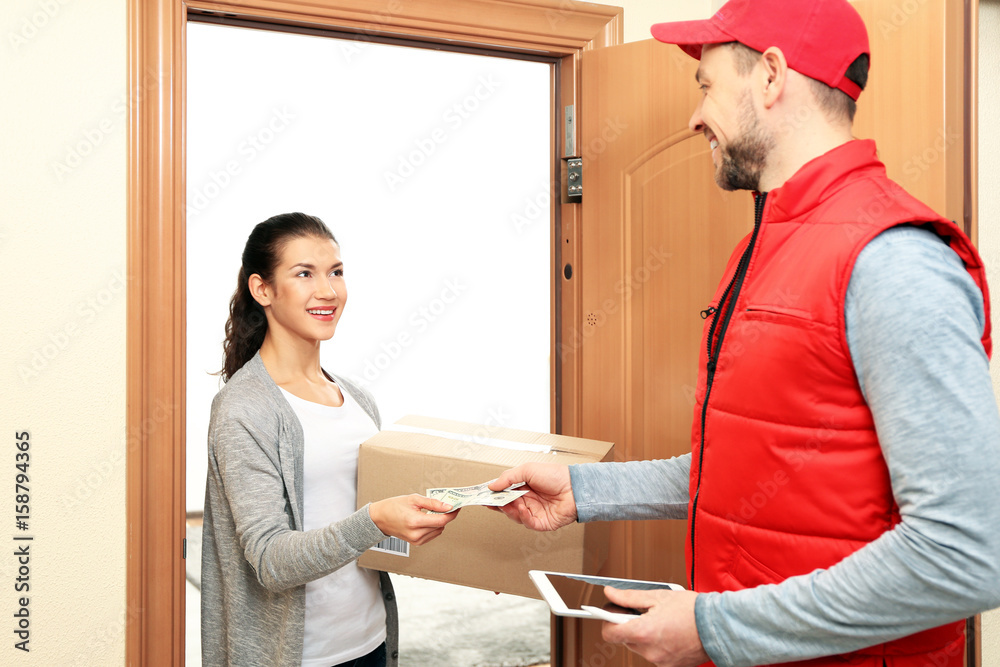 Young woman paying for parcel received from courier