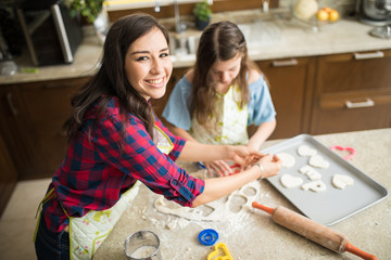 Wall Mural - Mom and daughter baking cookies together