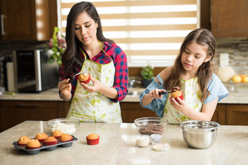 Wall Mural - Mom and daughter decorating cupcakes