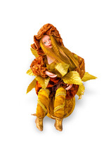 Doll With Autumn Leaves Sitting On A Ball.