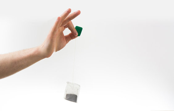 Fototapete - hand hold tea bag on a white background