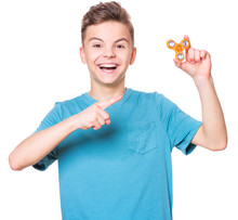 Young Teen Boy Holding Popular Fidget Spinner Toy - Close Up Portrait. Happy Smiling Child Playing With Spinner, Isolated On White Background.