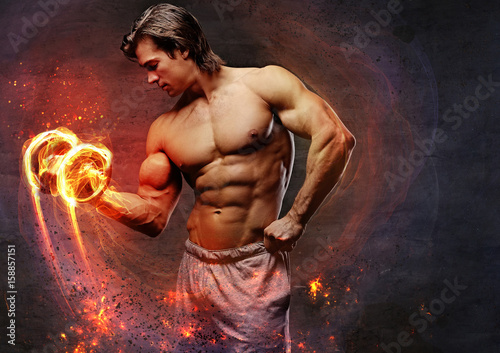 Fotografie, Obraz  The shirtless abdominal male holds dumbbell.