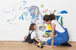 © Connect Images - Mother and daughter drawing on white wall