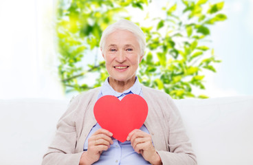 Wall Mural - happy smiling senior woman with red heart at home