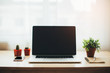 © karanik33 - Close-up of comfortable working place in office with wooden table and laptop laying on it