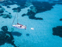 Aerial View Of A Sail Boat In Front Of Mortorio Island In Sardinia. Amazing Beach With A Turquoise And Transparent Sea. Emerald Coast, Sardinia, Italy...