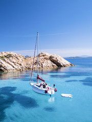 Wall Mural - Aerial view of a sail boat in front of Mortorio island in Sardinia. Amazing island with turquoise and transparent sea. Emerald Coast, Sardinia, Italy...