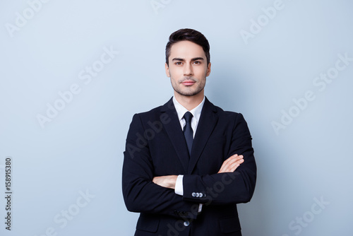 Valokuva Successful young handsome brunete hispanic man lawyer in a suit on pure background with crossed hands