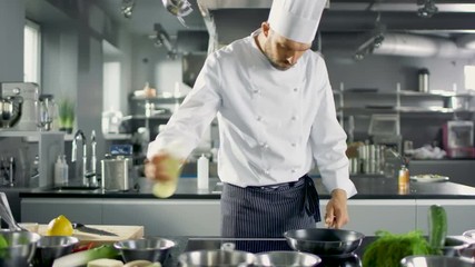 Wall Mural - Professional Chef Working in a Famous Restaurant Kitchen. Starts Preparing His Specialized Dish, Turns on Stove and Puts Pan with Oil on it. Shot on RED EPIC-W 8K Helium Cinema Camera.