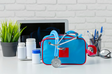 Wall Mural - Stethoscope, laptop and pills on the white table