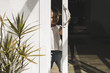 © Maskot - Happy girl opening glass door of house