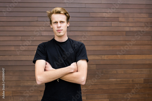 Tall Handsome Happy Young Man Standing On The Wooden Background