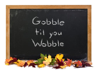 Wall Mural - gobble tip you wobble written in white chalk on a black chalkboard decorated with autumn fall leaves