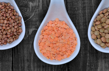 Wall Mural - Different types of lentils in a ceramic spoons