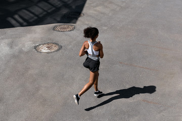 Wall Mural - high angle view of female runner on city street